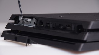 Anschließend müssen Sie eine einzelne Schraube entfernen, die den kleinen Festplatten-Käfig mit dem Gehäuse der PlayStation 4 Pro verbindet.