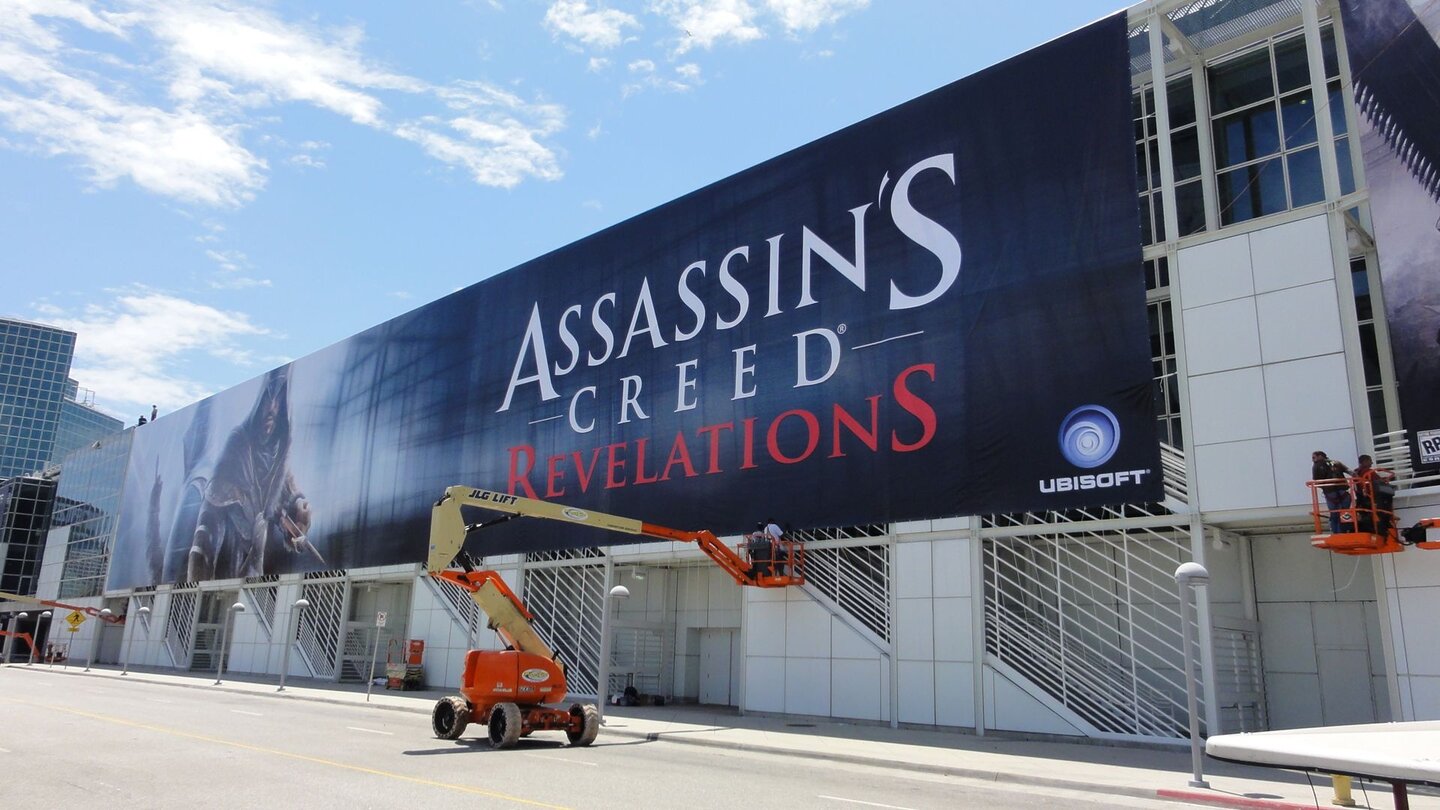 E3 2011: Schlacht um AufmerksamkeitUbisoft stellt das (bis jetzt) flächenmäßig größte Plakat der E3 2011 und nimmt mit Assassin’s Creed: Revelations die Außenfassade der Verbindung zwischen South- und Westhall ein.