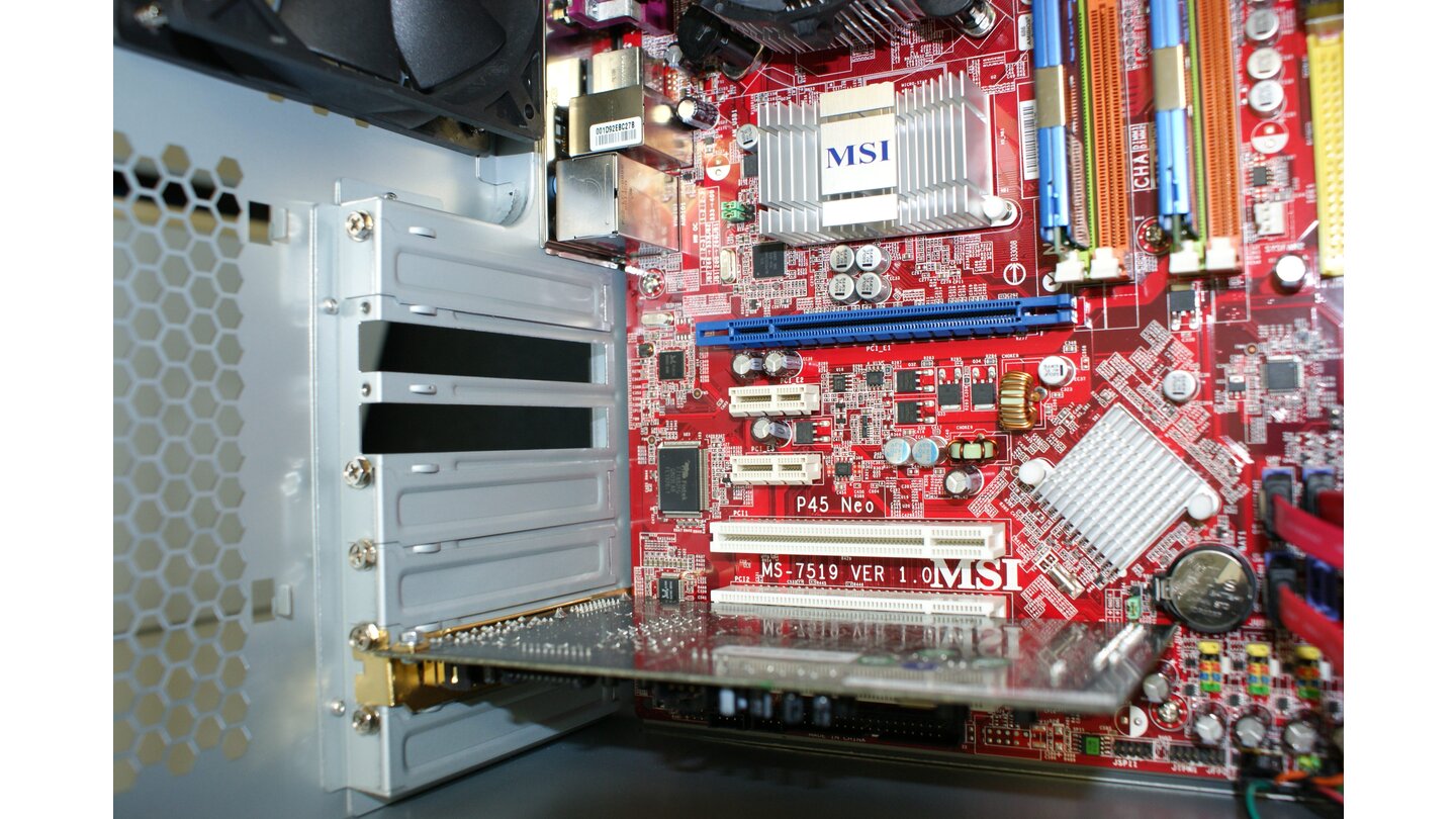 Das eingesetzte MSI-Mainboard P45 Neo-F besitzt einen PCI-Express-16x-Steckplatz für Grafikkarten. Im Bild ist das der blaue Slot schräg unter den RAM-Slots. Andere Mainboards verwenden andere Farben, die Form bleibt aber immer gleich. Um Platz für die Anschlüsse und den zwei Slot hohen Kühler der Radeon HD 4870 zu schaffen, entfernen Sie die beiden Slotbleche in der Gehäuserückwand auf die gleiche Weise wie beim Einbau der Soundkarte.