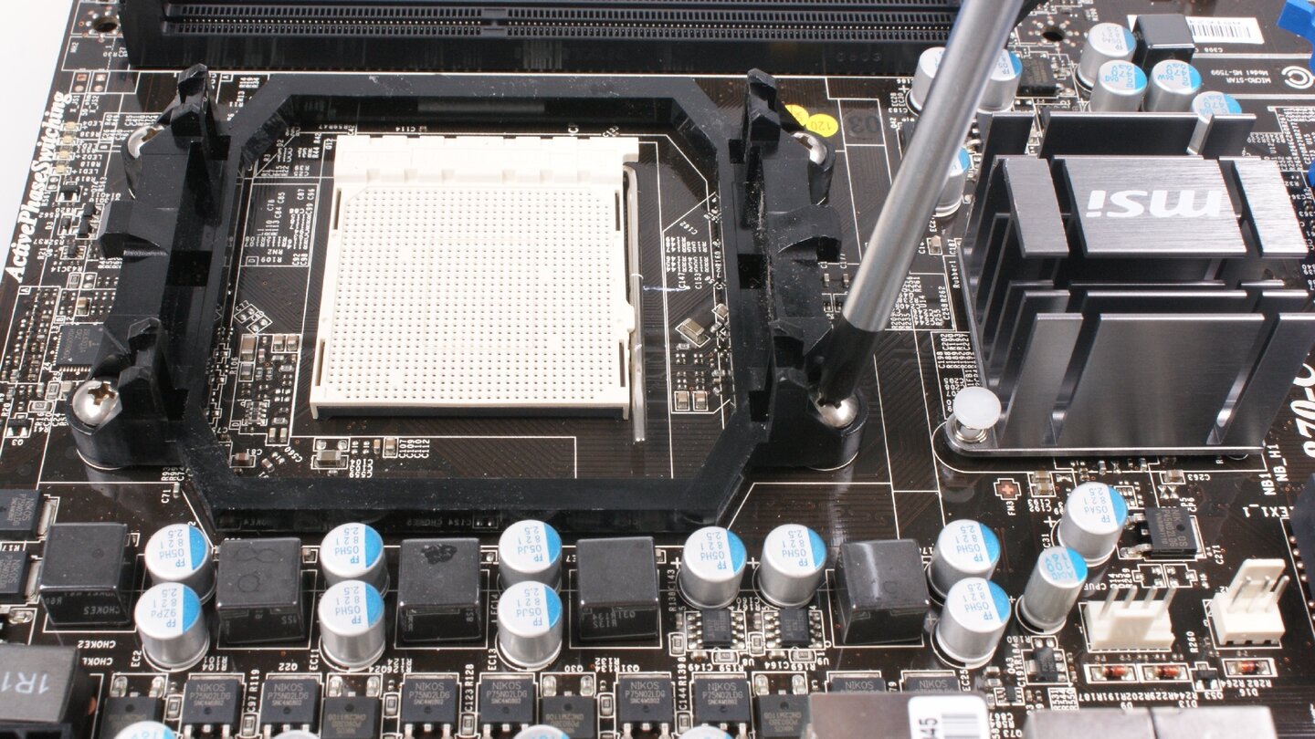 Bei Mainboards für AMD-CPUs müsst Ihr, wenn Ihr einen Austauschlüfter installieren wollt, der nicht auf die vormontierten Haltenasen aus Plastik setzt, den Standard-Befestigungsmechanismus abmontieren. Dazu entfernen wir als Erstes die vier Schrauben auf der Oberseite des Mainboards.