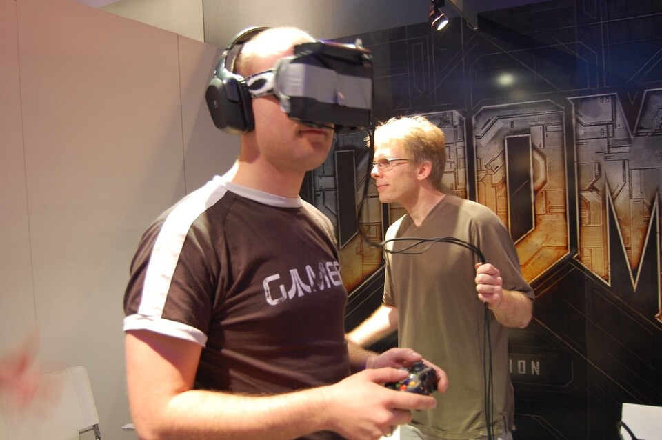 Redakteur Daniel Matschijewsky probiert John Carmacks (rechts) VR-System aus.
