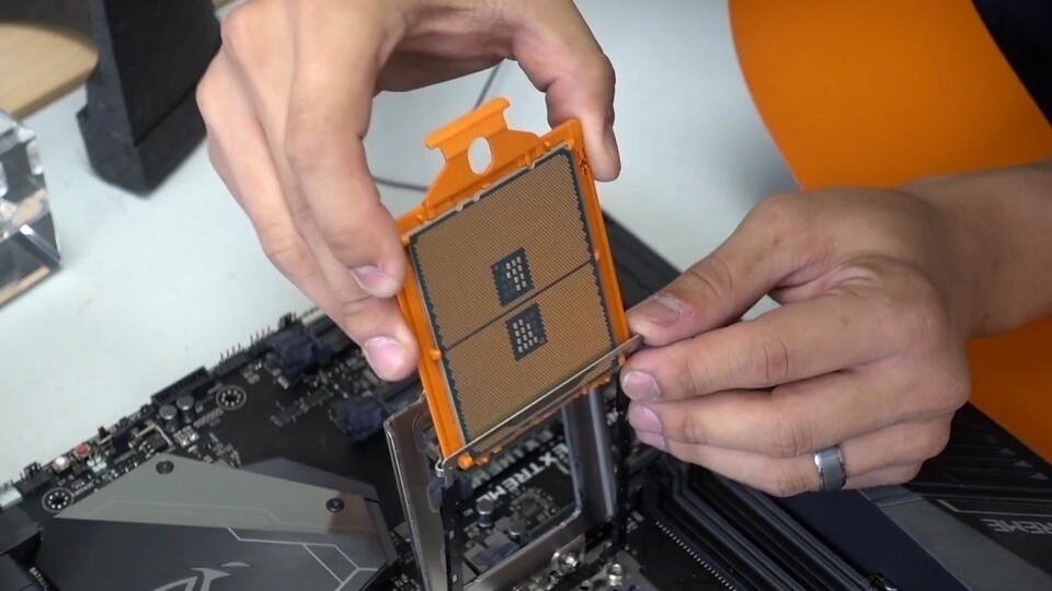 Bei der Installation wird die Threadripper-CPU mitsamt der orangefarbenen Halterung in eine Schiene am Sockel geschoben. Quelle: Youtube-Kanal Bitwit