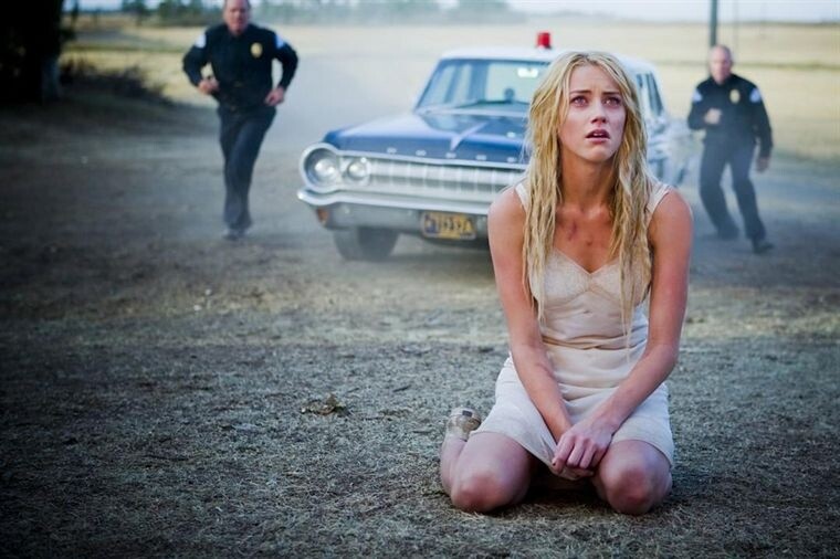 Kristen (Amber Heard) sitzt vor einem brennenden Haus und wird als Brandstifterin in die Anstalt eingewiesen.