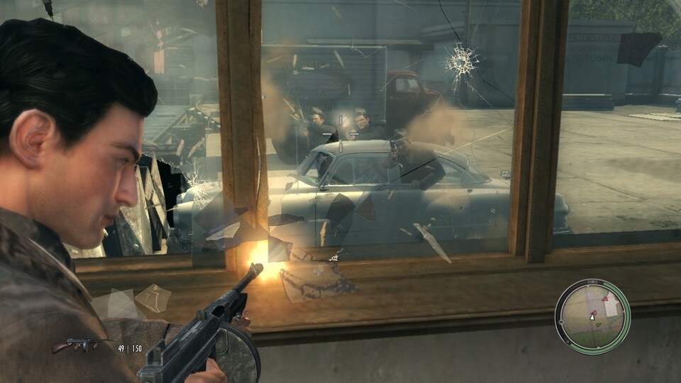 Mafia 2(PC): Mafiosi ballern wohl gern aus dem fahrenden Auto. Wir halten dagegen und zerlegen nebenbei eine komplette Fensterfront.
