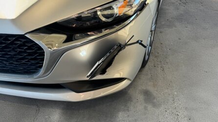 Autofahrer kam auf der Arbeit an und bemerkte einen blinden Passagier: ein Laptop, der in seiner Stoßstange steckt