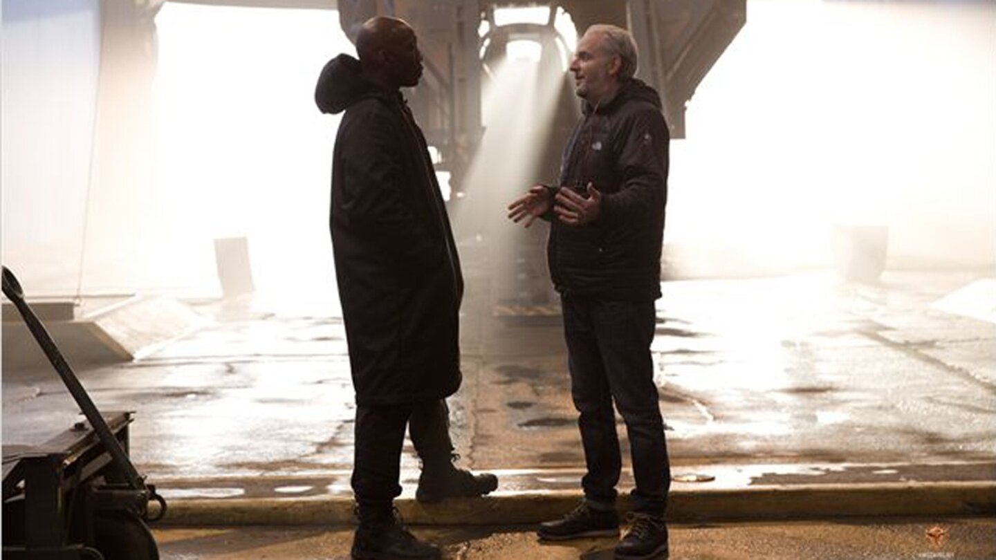 Die Tribute von Panem: Mockingjay - Teil 1Regisseur Francis Lawrence (li.) geht am Set mit Boggs-Darsteller Mahershala Ali die letzten Details durch.