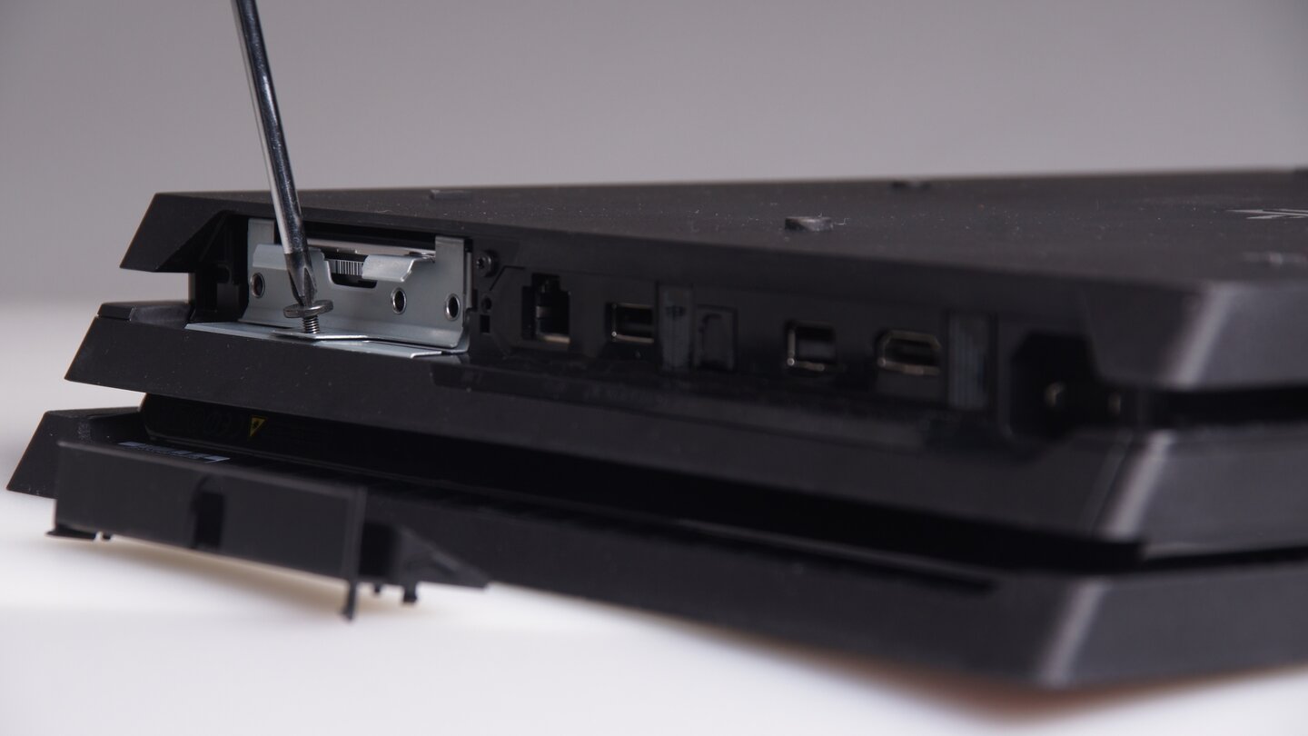Anschließend müssen Sie eine einzelne Schraube entfernen, die den kleinen Festplatten-Käfig mit dem Gehäuse der PlayStation 4 Pro verbindet.
