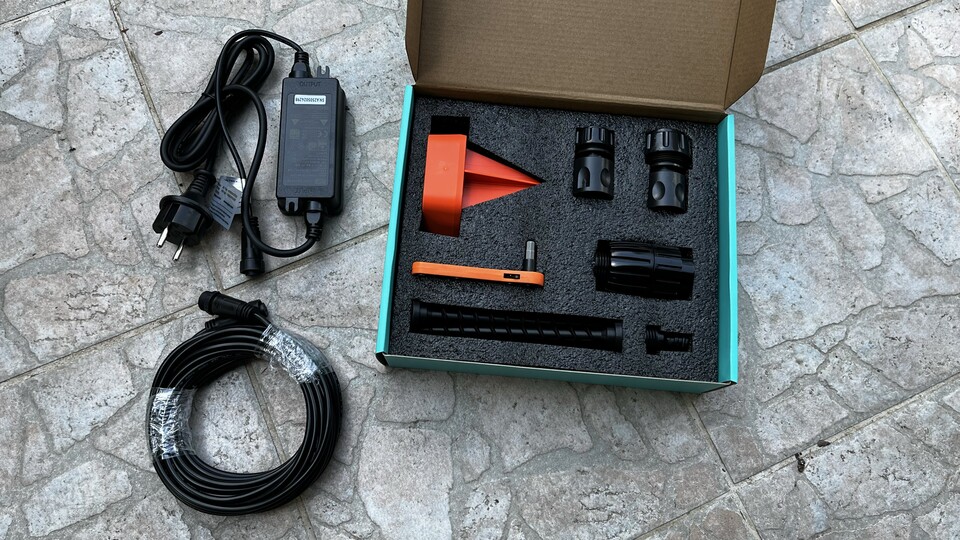 Der Lieferumfang: Stromkabel und -adapter, Werkzeug und Schrauben zum Fixieren im Boden sowie diverse Schlauchadapter.