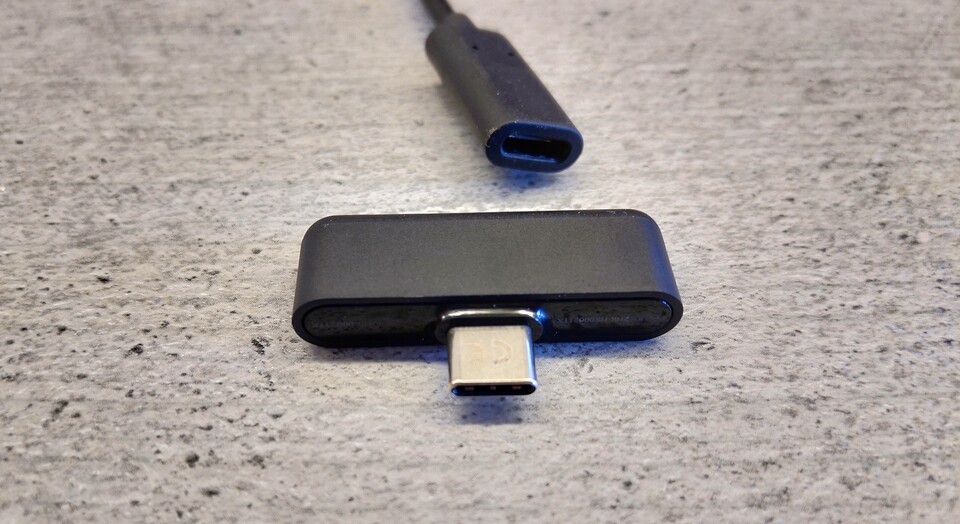 Der USB-C-Dongle funktioniert nativ auch an Nintendos Switch, für den PC liegt ein Adapterkabel (im Hintergrund) für gängige USB-Ports bei.