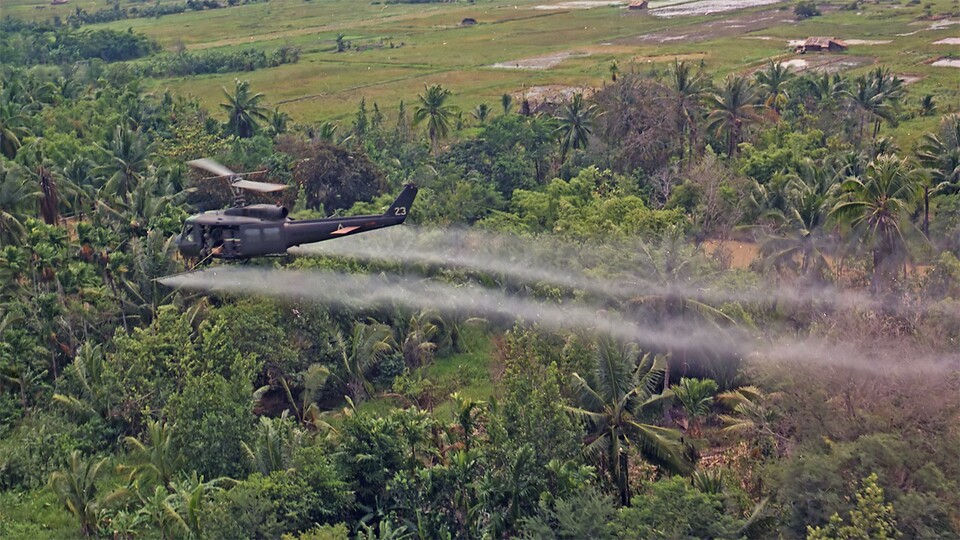 Ein amerikanischer Hubschrauber sprüht das Pflanzengift Agent Orange, um den Wald zu entlauben.