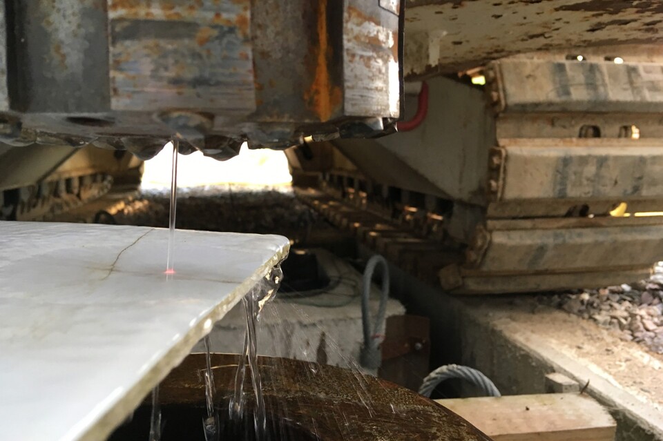 Am roten Lichtpunkt auf der Platte ist der testweise angeschaltete, von einer Wasserhülle umgebende Laserstrahl zu erkennen. (Bildquelle: Fraunhofer IPT)