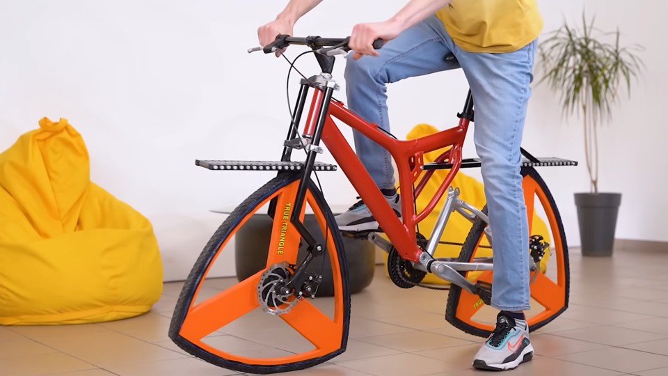 What should roll has to be round?  Oh no.  A bike can also have corners and edges.  (Image source: YouTube channel The Q)