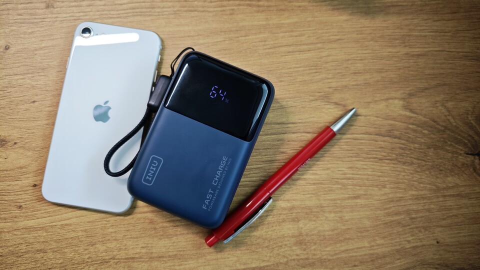 Die INIU Mini Powerbank war, neben meiner Kamera, das wichtigste Gadget für meine Arbeit auf der IFA. Hier seht ihr sie neben einem iPhone SE 3 und einem Kugelschreiber. (Bildquelle: Duy Linh DinhGameStar Tech)