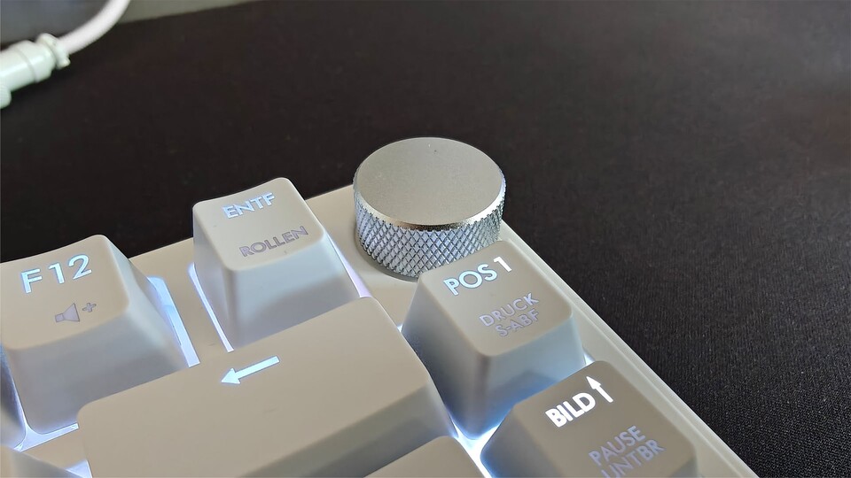 Oben rechts befindet sich der Lautstärkeregler aus Metall. Drückt ihr ihn von oben, wird der Systemsound stummgeschaltet.