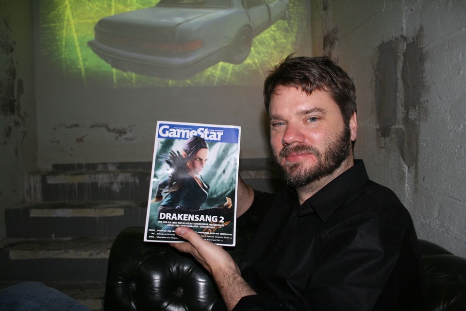 Chet Faliszek posiert mit der aktuellen GameStar-Ausgabe.
