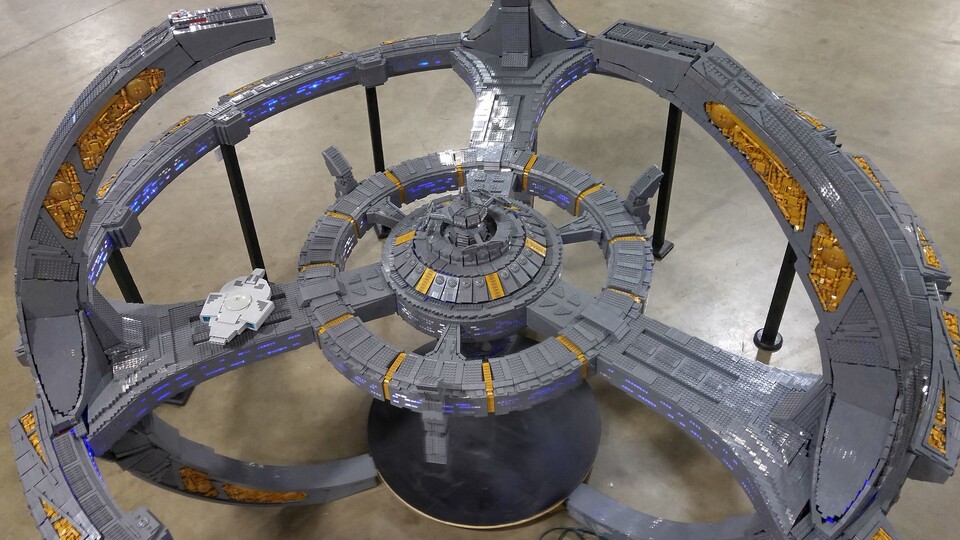 Ohne die schwarzen Stützen und ein Stahlgerüst im Inneren könnte das massive Lego-Modell von Deep Space Nine nichts ein eigenes Gewicht aufrechterhalten. Links seht ihr die maßstabsgerechte USS Defiant. (Foto: Adrian DrakeFlickr)