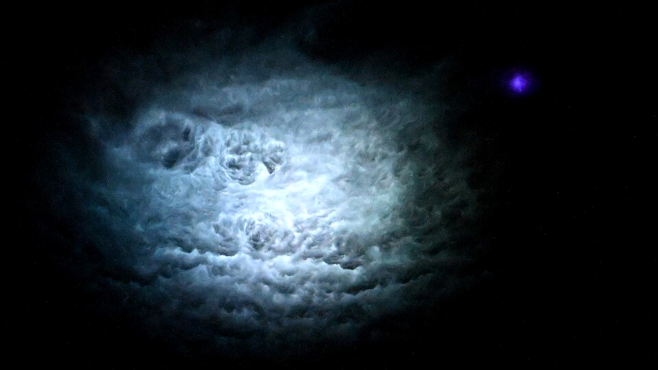 »Nadir-Ansicht eines Blitzes über der Kongo-Region in Afrika. Der Hauptblitz erhellt das Zentrum der Gewitterwolke, während ein blauer Jet, bekannt als Transient Luminous Event (TLE), einen blauen Punkt entlang der Peripherie der Gewitterwolke erzeugt. Ich habe Hunderte dieser Nadir-Fotos, und die blauen Strahlen sind typischerweise an den Rändern der Gewitterwolke zu sehen.«