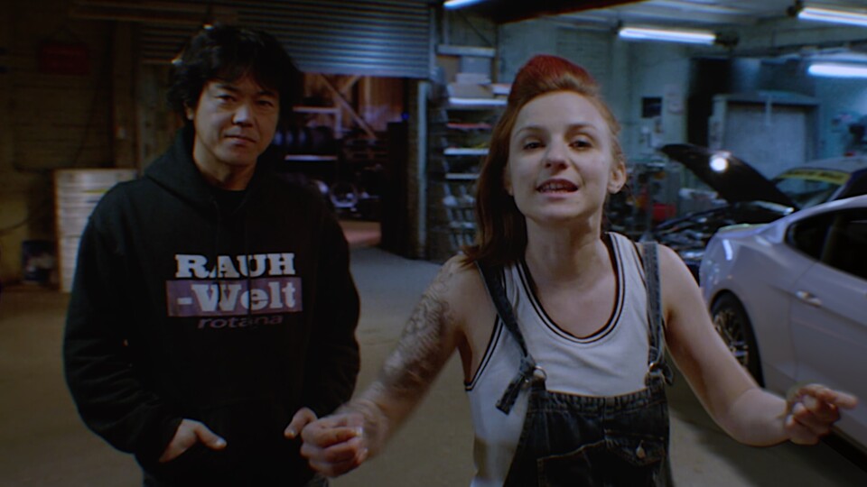 Es gibt Dutzende charmant-trashige Zwischensequenzen mit eurer Racing-Bande. Hier Faye Marsay (bekannt als Vel aus Andor) sowie Tuner-Legende Akira Nakai.