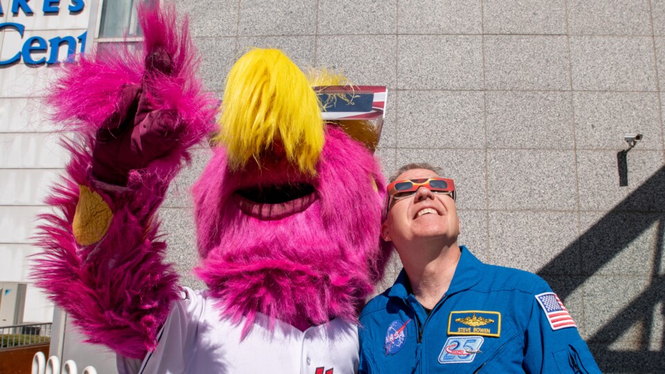 Genießt den Blick in die verdunkelte Sonne, aber tragt immer eine Schutzbrille, wie auch hier ein Sportmaskottchen und der NASA-Astronaut Stephen Bowen.
(Bildquelle: NASAGRCSara Lowthian-Hanna)