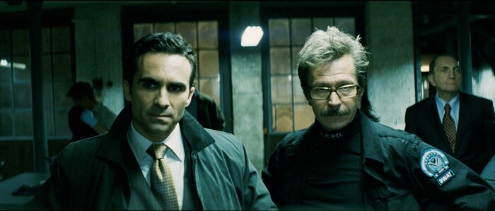 Gothams Bürgermeister (Nestor Carbonell) und Lieutenant Jim Gordon (Gary Oldman) beim Gefangenenbesuch. 