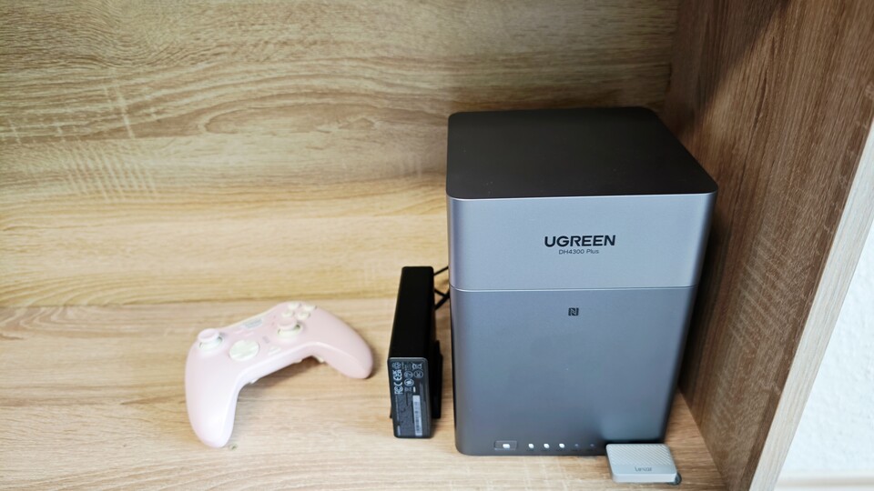 Das Ugreen NAS DH4300 Plus ist besonders kompakt. Hier seht ihr es neben einem Gamepad. Das kleine Gerät links davon ist ein sogenannter »USV«. Erkennt es eine Unterbrechung der Stromzufuhr, etwa durch einen Stromausfall, fährt das NAS-System korrekt herunter, sodass keine Daten verloren gehen. (Bildquelle: Duy Linh DinhGameStar)