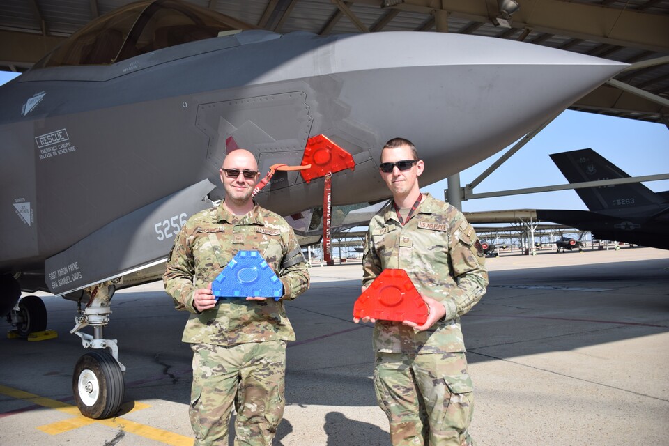 Sergeant Christopher ODonnell (links) und Sergeant Justin Platt posieren mit dem Ersatzteil aus dem 3D-Drucker (Bild-Quelle: David Roza vom Air + Space Forces Magazine)