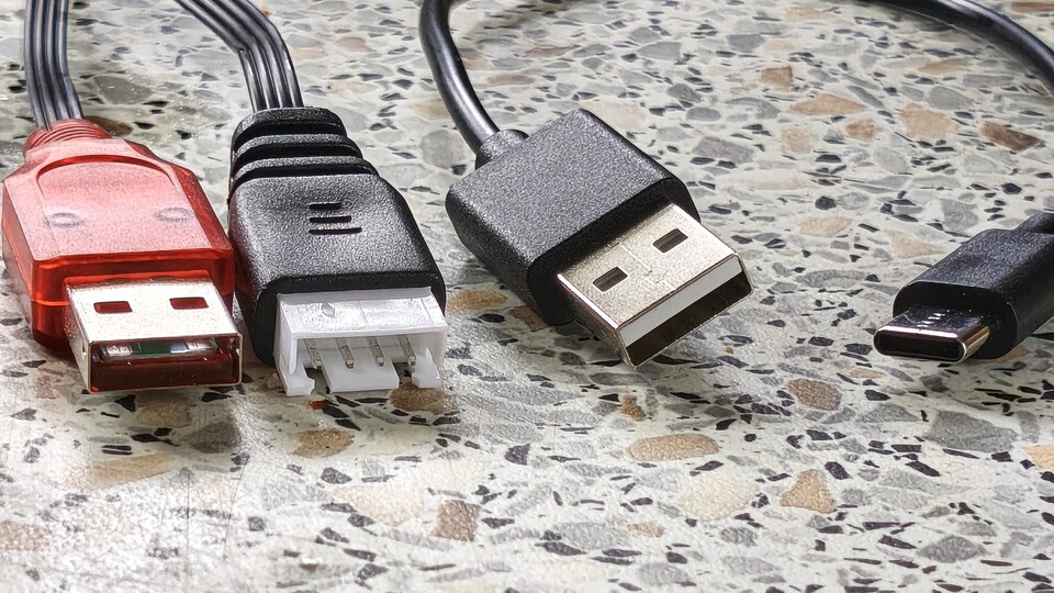 Rechts das normgerechte USB-Kabel der SpyraFour, links der seltsame Pfostenstecker mit Flachbandkabel der NoName-Variante.