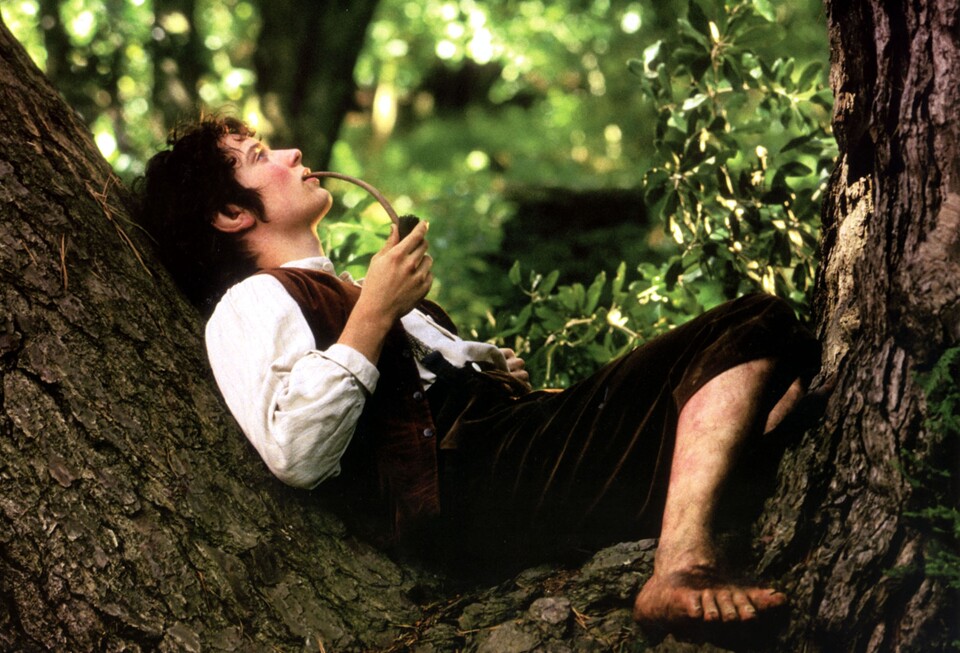 Frodo Beutlin beim Pfeife rauchen auf einem Baum. (Bild: New Line Cinema).