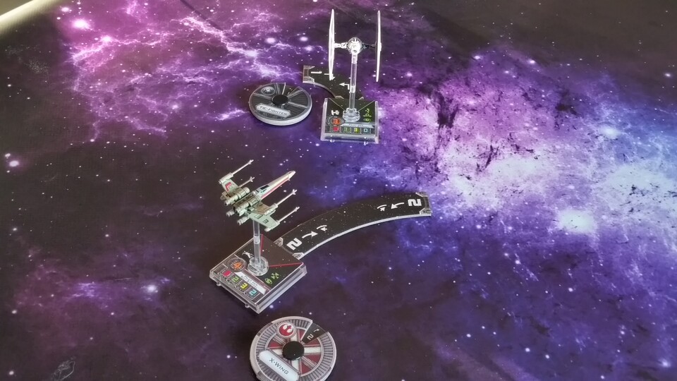 War wohl nix. Der Spieler des X-Wings hat sich verschätzt und eine sanfte Rechtskurve aufgedeckt, während der feindliche TIE-Fighter stattdessen hart nach links abdreht. Somit hat der X-Wing in der kommenden Angriffsphase kein Schussfeld auf den TIE.