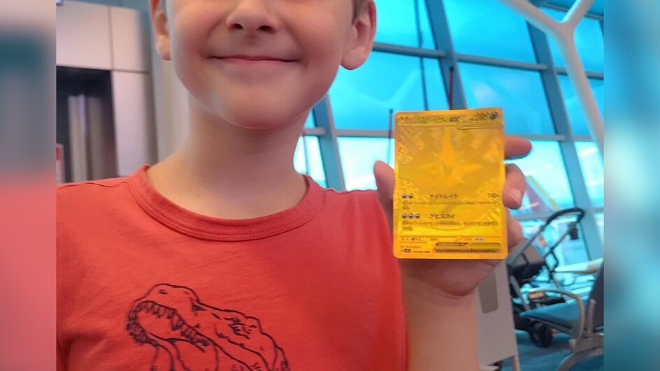 Teaserbild für Pokémon-TCG-Glückspilz steckt 10 Stunden am Flughafen fest, kauft überteuertes Pack für seinen Sohn, um die Zeit zu überbrücken - zieht Karte, die bis zu 1340 Euro wert ist