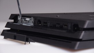 Anschließend entfernt ihr eine einzelne Schraube, die den kleinen Festplatten-Käfig mit dem Gehäuse der PlayStation 4 Pro verbindet.