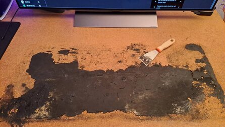 PC-Spieler zeigt die Überreste seines Mauspads - die sind so mit dem Tisch verschmolzen, dass er sie selbst mit einem Spachtel nicht abbekommt