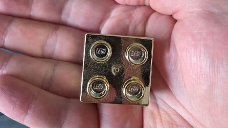 LEGO-Mitarbeiter zeigt, was er zum vierten Jubiläum bekommen hat - einen goldenen Legostein, den wir jetzt unbedingt auch haben wollen