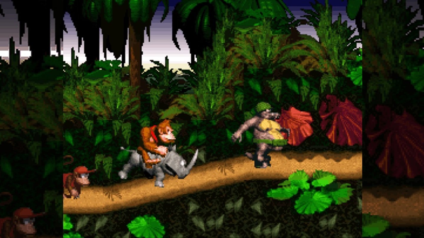 Donkey Kong Country (SNES, 1994)
Nur ein Monat nach dem Game-Boy-Ableger erschien Donkey Kong Country, das nicht bei Nintendo, sondern bei Rare in England entstand. In DK Country wurde Donkey Kongs Bananenvorrat von den Kremlings gestohlen, nun muss der Spieler zusammen mit Diddy Kong die Bananen zurückholen. Dabei kehrt der Titel zurück zu den Plattformer-Wurzeln und liefert einen Single- wie auch einen Multiplayer-, der Koop-Modus fehlte dagegen noch. Neben den Hüpf- und Sprungeinlagen waren Levels mit anderen Tieren ein zentrales Spielelement. Rhino Rambi und Papagei Squawks sind dabei nicht nur einfache Helfer, sondern zwingend nötig für das Erreichen von Bonusleveln.
Donkey Kong Country war für damalige Verhältnisse ein grafischer Meilenstein, der statt auf echten 3D-Modellen auf vorgerenderte 3D-Figuren setzt, die nochmals detaillierter waren. Der Titel erhielt nicht nur von Kritikern Lob, sondern war auch bei den Spielern sehr beliebt: Mit neun Millionen verkauften Spielen war es der erfolgreichste SNES-Titel.