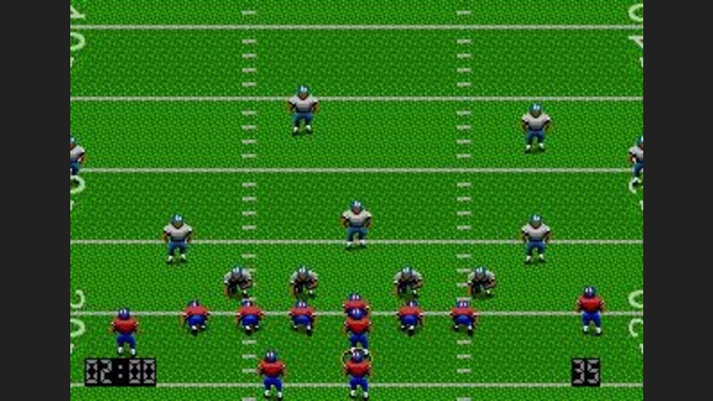 At the scrimmage line. In the Genesis version the action is viewed from a top-down perspective
