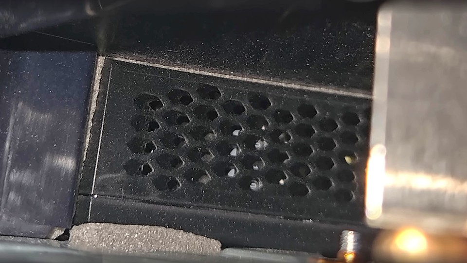 Hebt ihr den Lüfter aus der PS5, könnt ihr ins Gerät schauen und mit einem langen Pinsel den Kühlergrill des Netzteils reinigen.